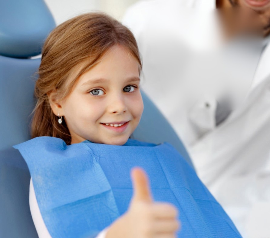 Bambina sorridente sulla poltrona del dentista