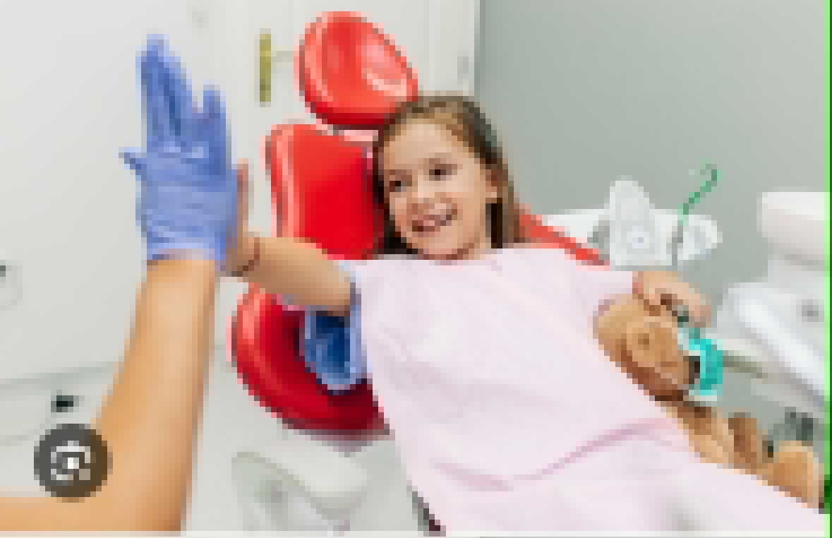 Bambina sorridente sulla poltrona del dentista